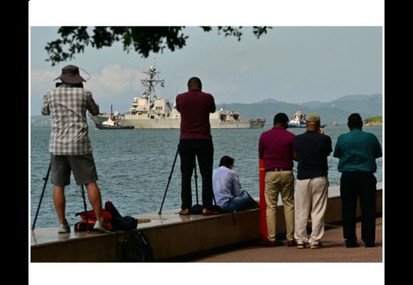Le public prend des photos de l'USS Gravely, un navire de guerre américain, quittant le port de Port of spain le 30 octobre 2025. Le navire de guerre américain était arrivé à Trinidad-and-Tobago le 26 octobre 2025 pour des exercices conjoints au large du Venezuela, alors que Washington intensifiait sa pression contre les trafiquants de drogue et le dirigeant vénézuélien Nicolas Maduro. Photo : Martin Bernetti / AFP
